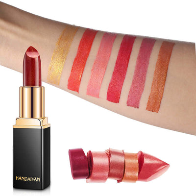 Shiny metallic lipstick with multiple pearlescent shades swatched on arm and black gold tube packaging