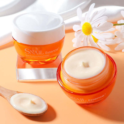 Facial moisturizing cream lotion in orange jar with white lid and cream texture with daisy flower on peach background