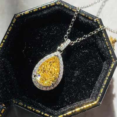 Yellow zircon water drop necklace inlaid in copper, designed for women, displayed in a black hexagonal box.