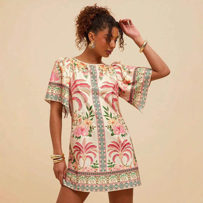 Woman wearing a retro crew neck short A-line dress with horn floral print and bell sleeves.