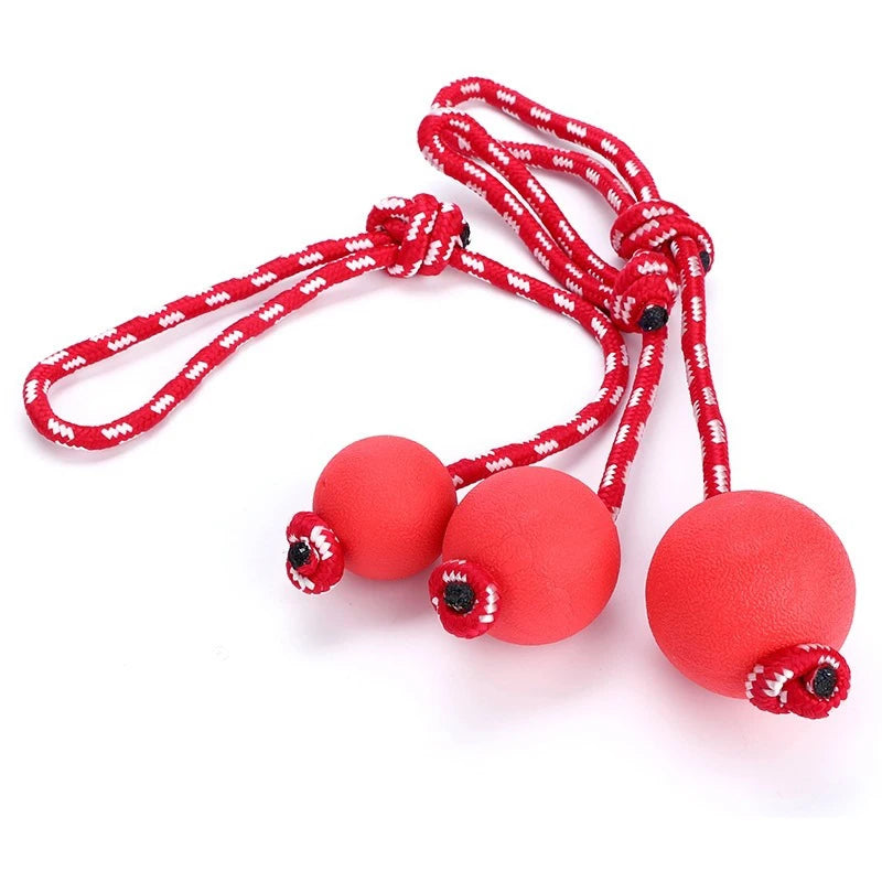 Manufacturer wholesale red dog ball Training dog chewing solid rubber elastic ball wearing rope pet toy with rope elastic ball