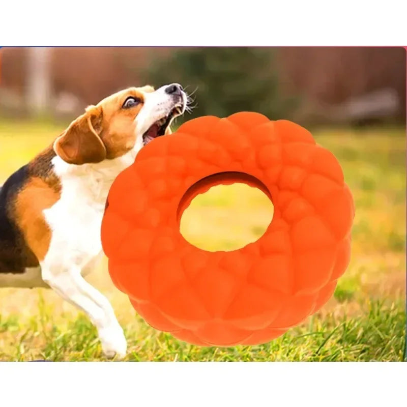 Orange rubber pet dog chewing toy with round design for foraging and interactive play.