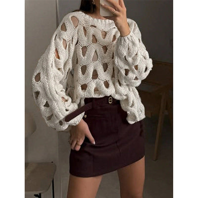 Womens white hollow-out crochet knit crewneck sweater with long sleeves paired with a dark mini skirt