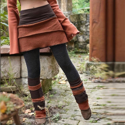 Woman wearing brown and black color block asymmetrical skort with leggings outdoors in autumn setting