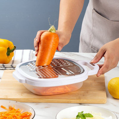 Multifunctional stainless steel lunch box grater in use with carrot.
