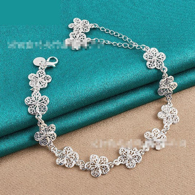 Silver flower bracelet for women on turquoise background.